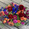 A mixed arrangement with an assortment of delphinium, roses, gerberas, matsomo asters