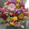 A colorful, mixed bouquet with tulips, gerberas, ranunculus, hydrangea, and button pomps.