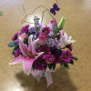 A pink and purple arrangement with pik lilies, purple daisies with curly