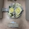 Classic spray roses intertwined with greens and matching ribbon create this elegant