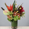 In this beautiful glass vase there rests red gingers, anthurium, hydrangeas &amp;