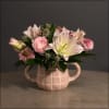 Adorable pink pot filled with lilies, ranunculus, scabiosa, eryntium thistle, and cymbidium