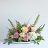 Blending timeless blooms, flowers like roses and hydrangeas give this centerpiece a