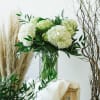 Large cylinder heavy glass vase filled with a mixture of white hydrangeas