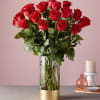 12 red roses vased arranged with lush greenery
