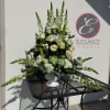 A sympathy pedestal arrangement offers a heartfelt expression of condolence, featuring a