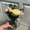 A small glass mason jar delicately arranged and prepared with fresh cut