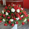 Red roses, white carnation, red hypericum and red bow
