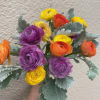 Ranunculus with dusty miller wrapped in mesh. This is a hand-tied bouquet.