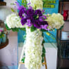 white hydrangea cross with purple lisianthus and lavender stock flowers.