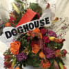 ASSORTED BLOOMS BUILT INTO A DOGHOUSE WITH A BONE. SURE TO GET