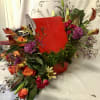 ASSORTED BLOOMS BUILT INTO A DOGHOUSE WITH A BONE. SURE TO GET