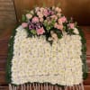 White flower blanket with pink accent for top of casket