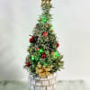 Holiday tree. Lavender tree decorated with lights, ornaments and a gold bow.