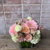 A cute displace of peach color roses, white hydrangeas, and pink gerbera