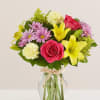 All-around arrangement with hot pink roses; yellow Asiatic lilies and carnations; lavender