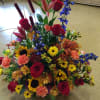 A mixture of fall colored flowers in reds, orange, peach, rust, yellow