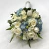 A lush mix of white flowers designed within a blue hydrangea. 