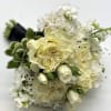 A lush mix of white flowers accented with black pearl sprays with