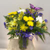 A Vase arrangement with a variety of yellow and purple flowers. 