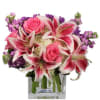 Glass cube vase filled with beautiful stargazer lilies, hydrangea, roses, fragrant stock