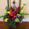 A bright and colorful mix of Red Roses, Blue Delphinium,  Orange