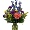 Kindness is catching in this clear glass vase arranged with blue delphinium