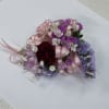 Pink, red and purple corsage with pink ribbon.