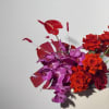 -A radiant mix of purple orchids, red painted leaves, bright Gerbera daisies