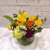 Dazzling jewel tone hues bring delight packed into this desktop sized arrangement.