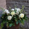 This arrangement of clean white blooms and fresh foliage is designed to