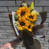 Premium wrapped sunflowers with accenting filler flowers, tied together with a satin