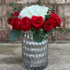 Twelve beautiful roses encircle a white hydrangea, presented in a patterned metallic
