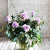 Beautiful Dozen in a glass vase with greenery and filler
