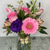 Arrangement of mixed flowers designed in a pastel color iridescent vase. Vase