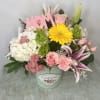 Bright mixed flower arrangement designed in a green metal tin container embellished