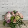 Light colored blooms of soft pinks, whites, green, and touches of purple.