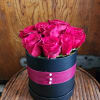 13 stems of red roses presented in a hatbox style container. Accented