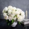  A lavish arrangement of over 20 pristine white peonies nestled within