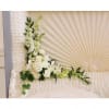 This serenely beautiful arrangement of white orchids, white roses and other popular