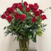 Three dozen roses arranged in a vase with gorgeous greenery will surely