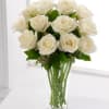 A dozen white roses delivered in a clear glass vase with minimal