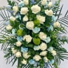 A serene and heartfelt funeral spray featuring delicate blue flowers, symbolizing peace