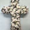 A stunning white floral cross designed for funeral services and memorial tributes.