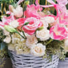 This charming basket bouquet brims with delicate pink roses, creamy white spray