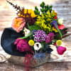 Hand tied medley of seasonal flowers presented in a black kraft paper