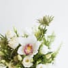 A Delicious arrangement of heavenly white lisianthus thistle and glorious cymbidium orchid.