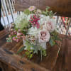 Roses, cymbidium orchids, hydrangea, pink stock, ranunculus, tulips, wax flower, berries, seeded
