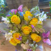 Wrapped bouquet of popping yellows and accents pastels and a butterfly 