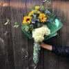 A bouquet of sunflowers and hydrangeas made with long greens that want